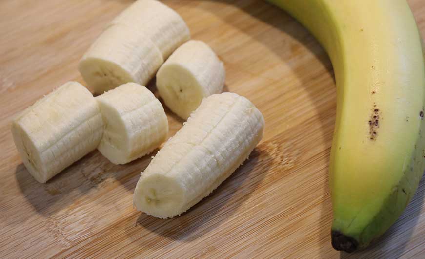 Banane ganz und geschaelt und in Stuecke geschnitten