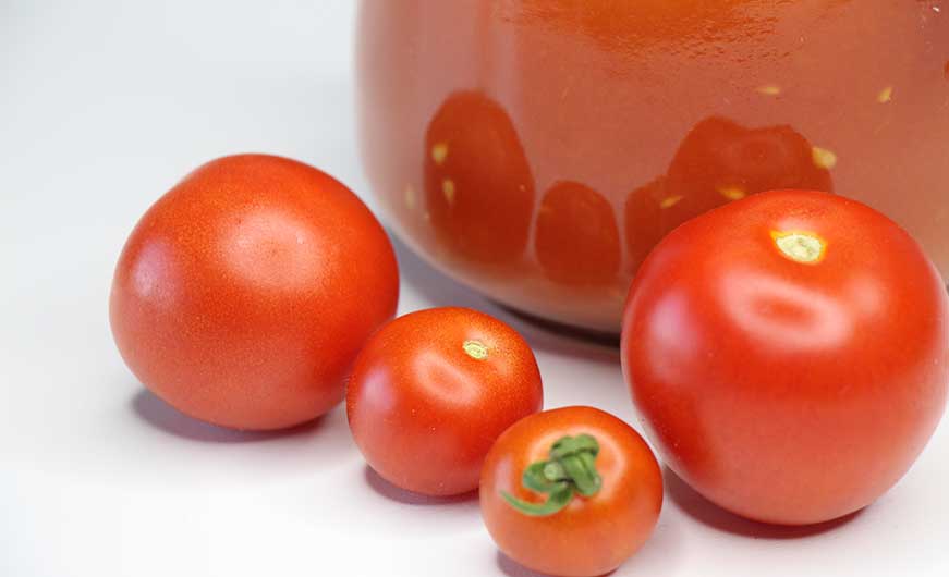 tomaten rot vor glas mit passierte tomaten